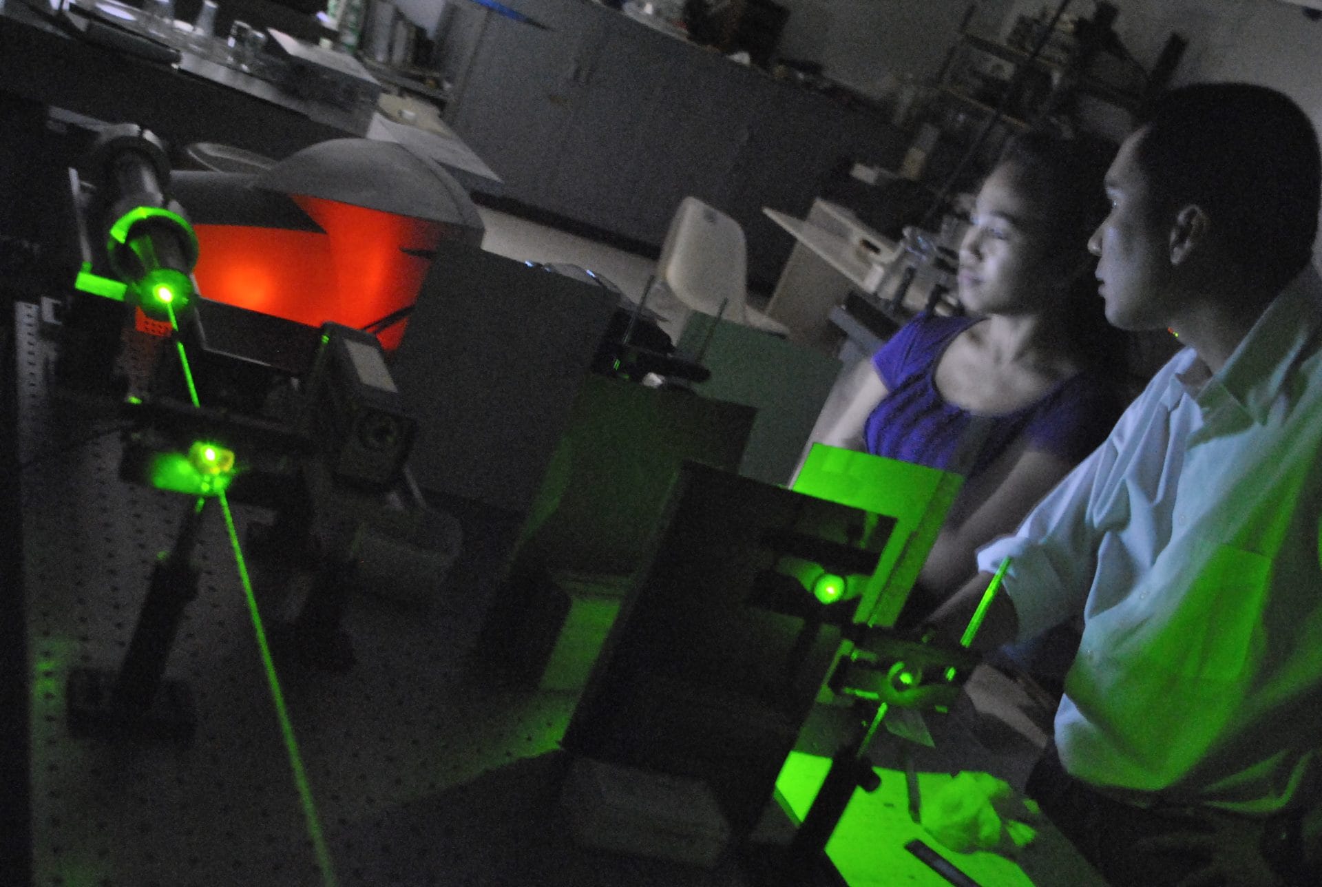 Chemistry &mdash; Students observing a laser optics experiment in a physics laboratory.